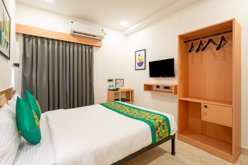 OH2 Hotel Karmanghat – Deluxe room with wardrobe and TV