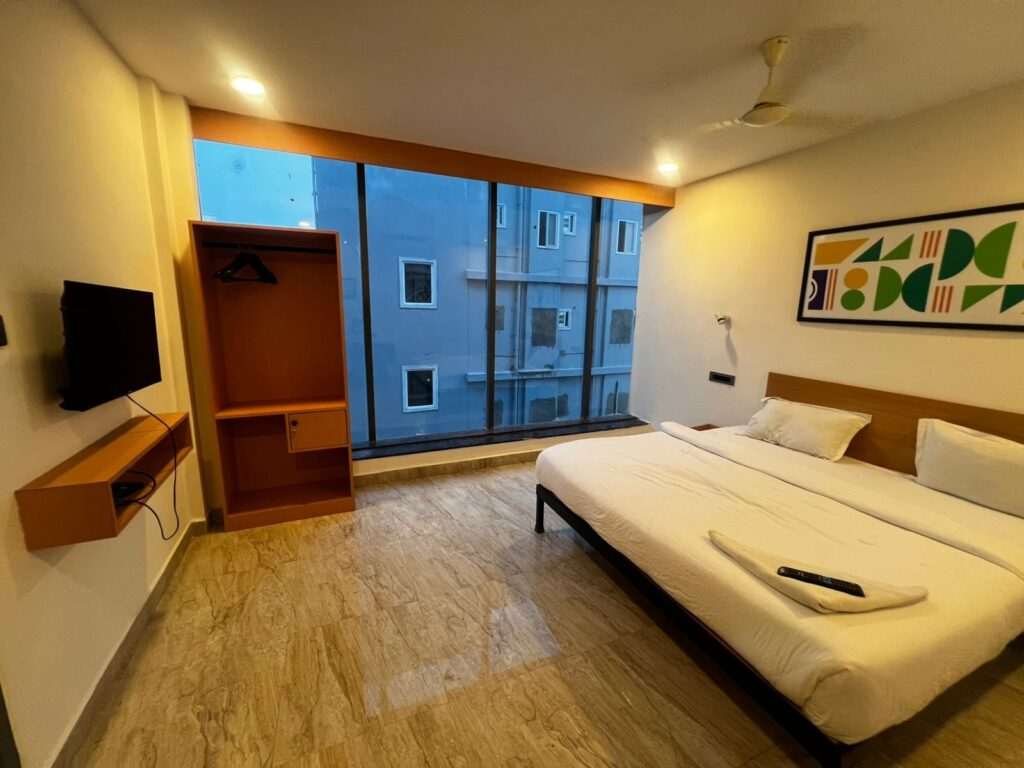 OH2 Hotel Karmanghat – Room with glass wall and TV